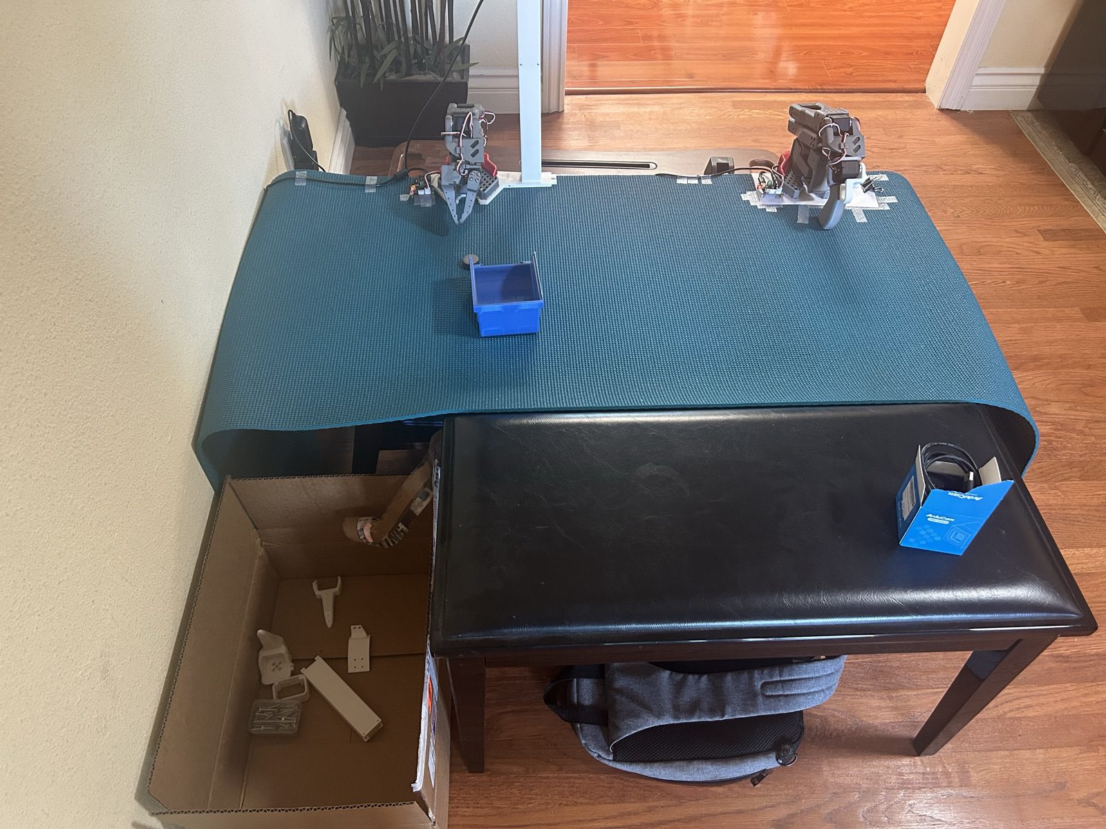 Overhead view of the rig: two arms, the sorting mat, and a parts bin
